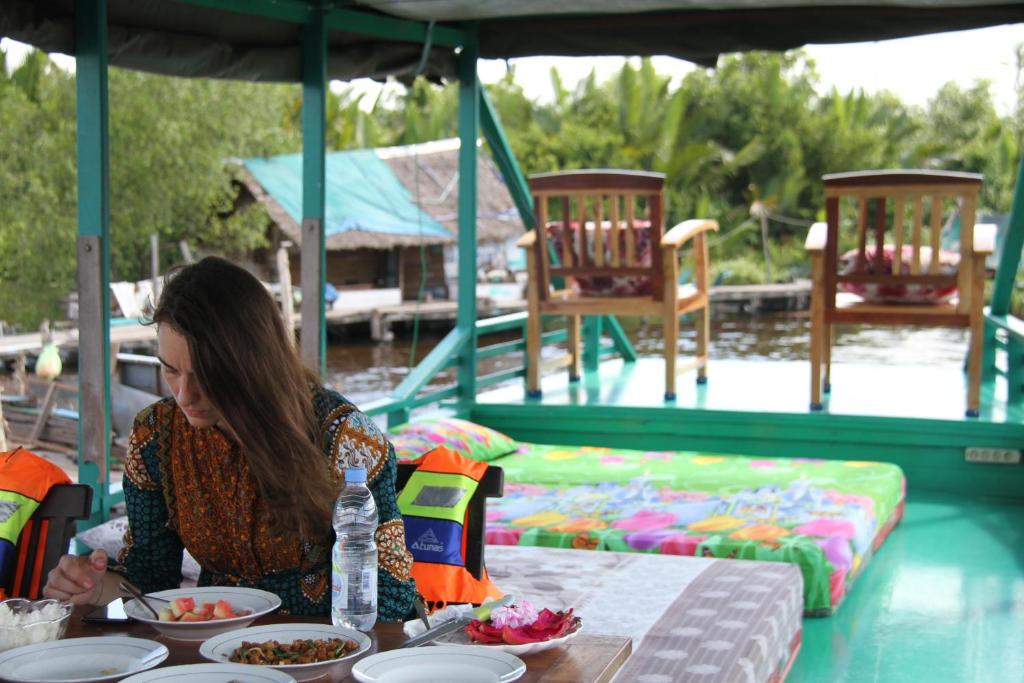 パンカランブーンにあるOrangutan Kelotok Houseboat for 6 personの食卓に座る女
