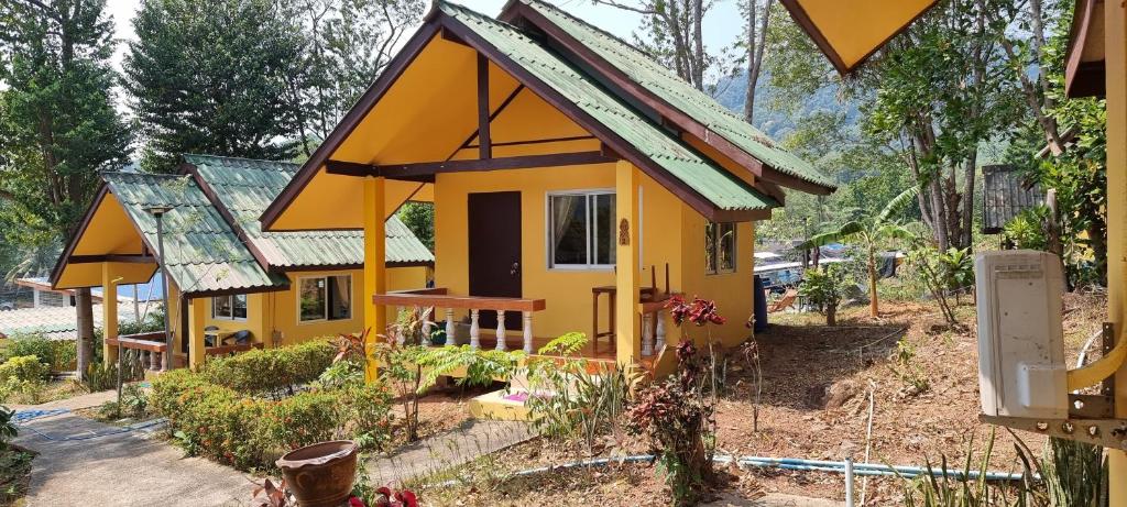 a small yellow house with a green roof at Wild Hippie Chang 