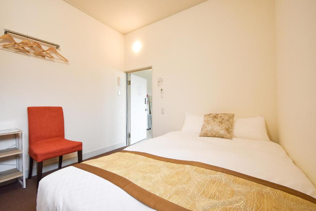 una camera da letto con un letto e una sedia rossa di Comfy Stay Sarusawaike a Nara