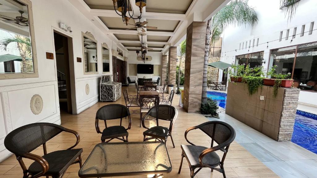 eine Terrasse mit Stühlen, Tischen und einem Pool in der Unterkunft Hotel Patrimonial by Greenfield in Guayaquil