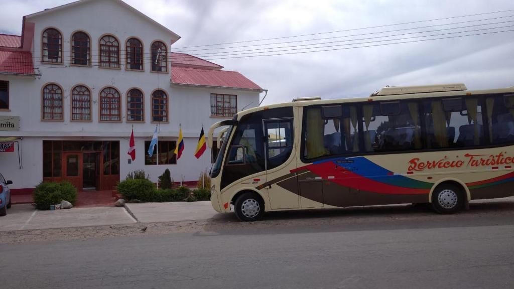 um autocarro estacionado na rua em frente a um edifício em Hotel Summita em Yunguyo
