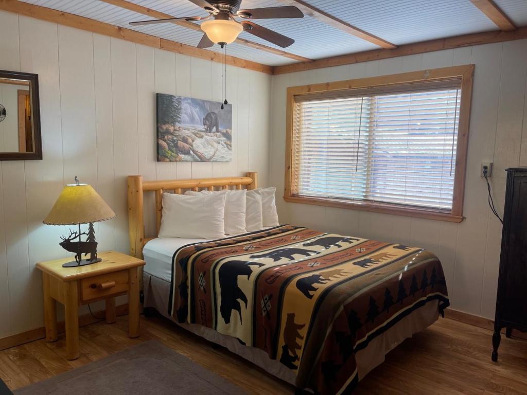 a bedroom with a bed and a lamp and a window at Red River Condo #4 in Red River