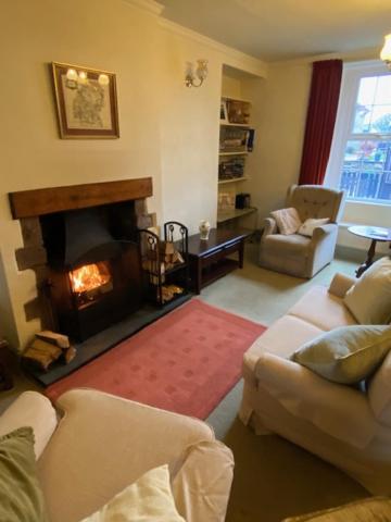 sala de estar con chimenea y sofá en lake District cottage, en Bootle