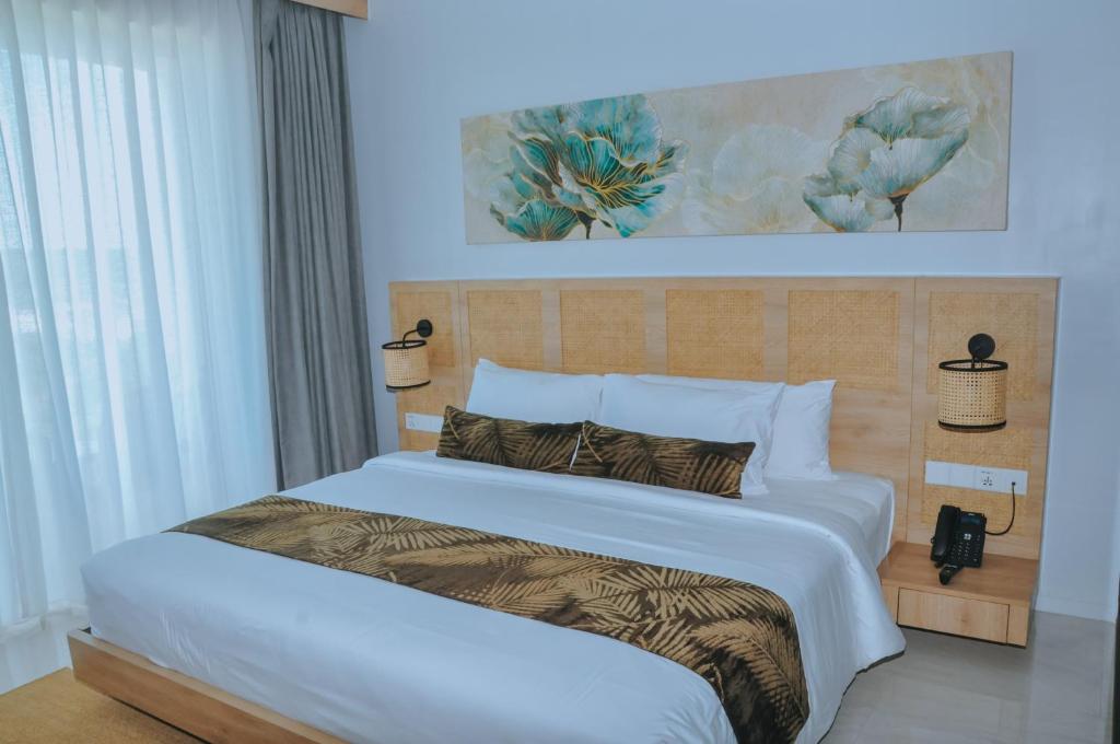 a bedroom with a large bed with a white bedspread at Truntum Boutique Mandalika in Kuta Lombok
