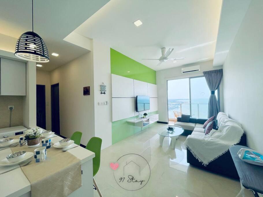 ein Wohnzimmer mit einem Sofa und einem Tisch in der Unterkunft SilverScape 4px Seaview Bathtub TVBox Games in Malakka