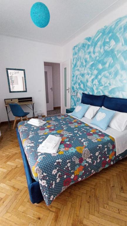 Hotel Casa di Raffi Sanremo, a bedroom with a large bed with a blue headboard at Casa di Raffi Sanremo in Sanremo
