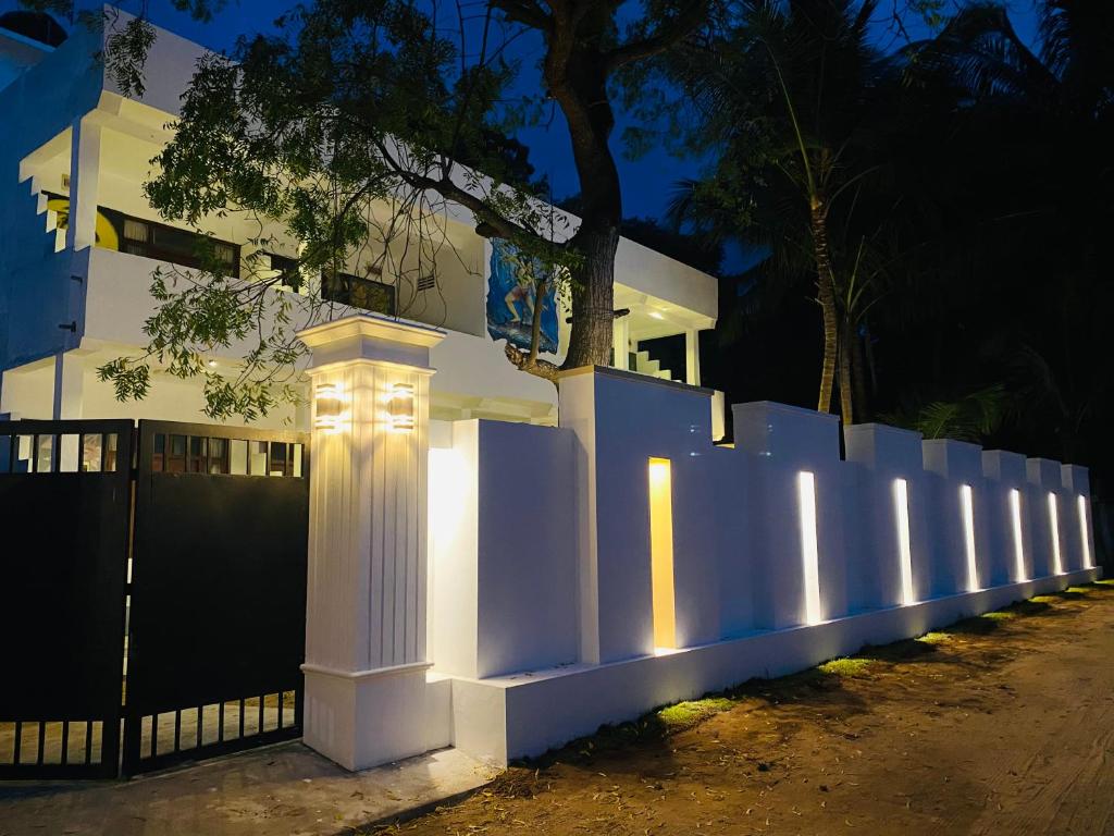 een wit hek voor een huis 's nachts bij Rams Resort in Arugam Bay