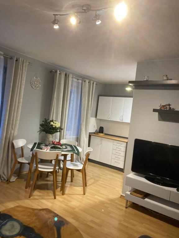 a living room with a table and chairs and a kitchen at Apartament Deluxe in Jelenia Góra