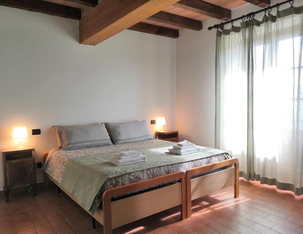 una camera bianca con un grande letto e una finestra di B&B Demetra a Solignano