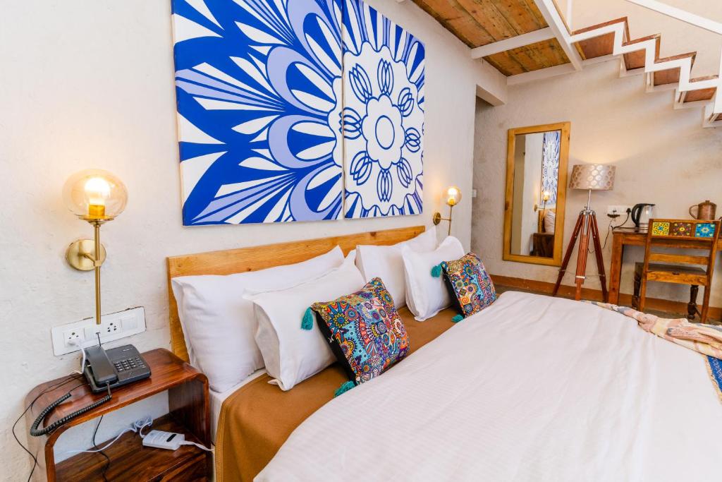 1 dormitorio con 1 cama con una pintura azul y blanca en la pared en SHIVAYA since 1953 en Mukteswar