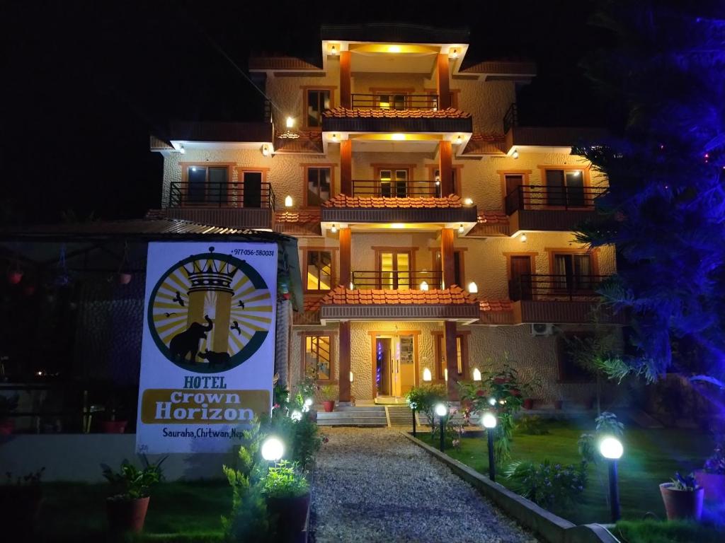 a building with a sign in front of it at night at HOTEL CROWN HORIZON in Sauraha