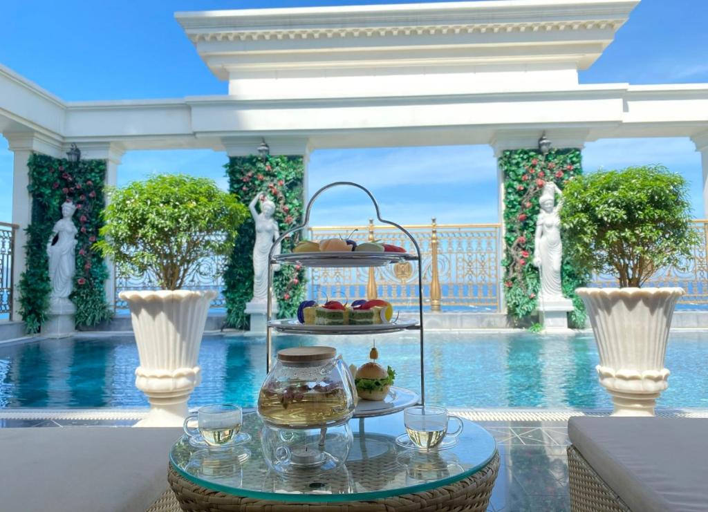 uma bandeja de comida numa mesa em frente a uma piscina em Monarque Hotel Danang em Da Nang