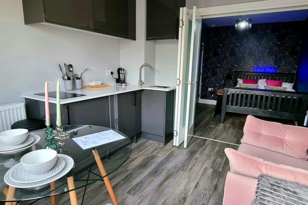 a kitchen and a living room with a glass table at Boutique Annexe Close To Norwich City & Airport in Horsham Saint Faith