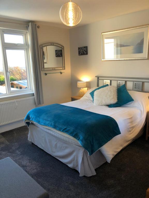 a bedroom with a large bed and a window at High Ways House in Woolacombe