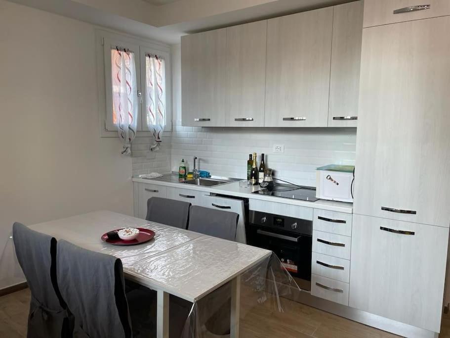 a kitchen with white cabinets and a table with a plate on it at Casa di Mattia in Villanova