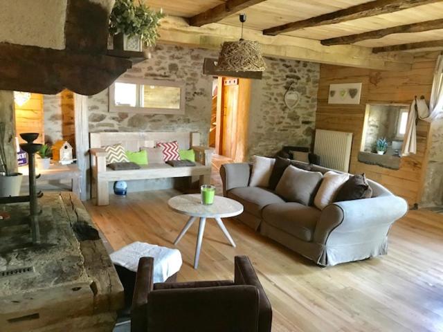 ein Wohnzimmer mit einem Sofa und einem Tisch in der Unterkunft La cabane de CHEMMALY in Flavin