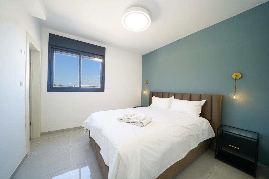 a bedroom with a large white bed with a window at Maorissimo tower in Acre