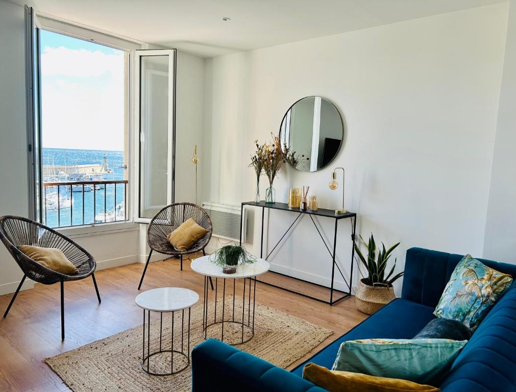 - un salon avec un canapé bleu, des fauteuils et un miroir dans l'établissement Sognu di Matteu - Bel appartement entièrement climatisé - vue mer, vieux port Bastia, à Bastia