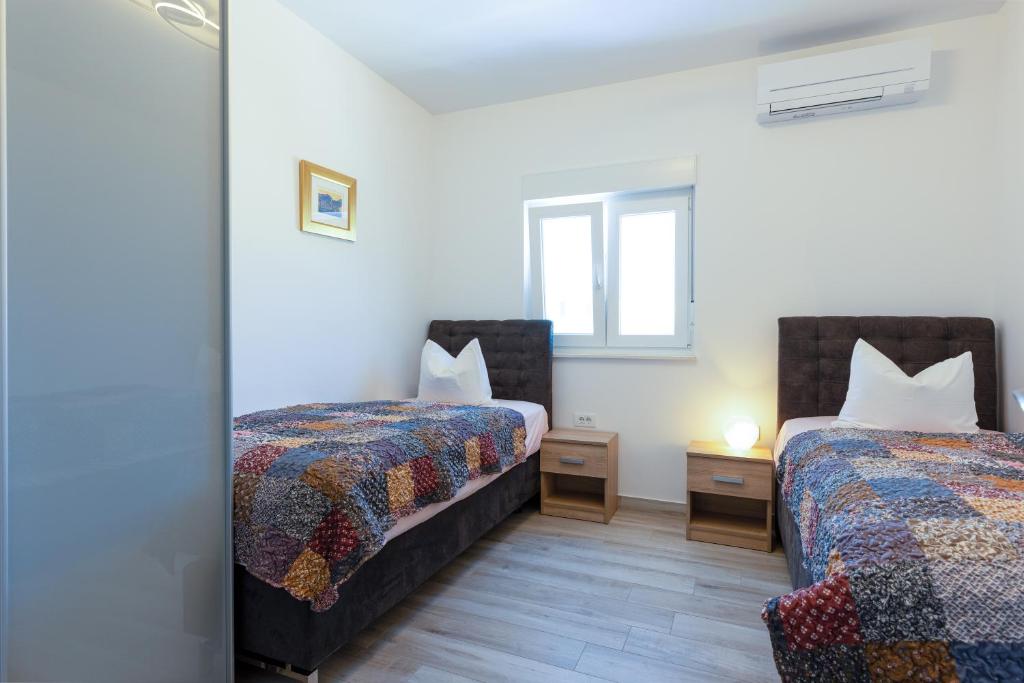 Cette chambre comprend 2 lits et un miroir. dans l'établissement Ferienhaus Relax - beheizter - heated Pool, à Kaštela