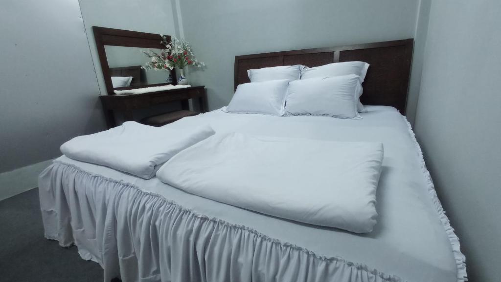 1 cama grande con sábanas y almohadas blancas en Enjoy Mekong Hostel, en Can Tho