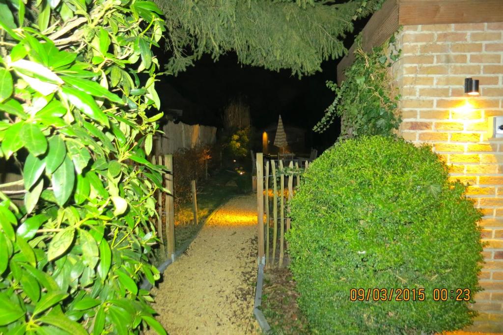 a garden with a gate and a brick building at Holiday home Harmony in Brecht