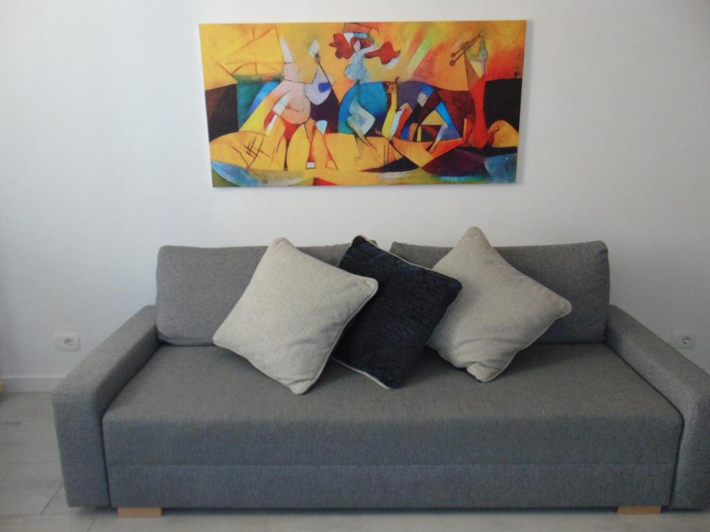 a couch with pillows and a painting on the wall at Casa Da Cri in Rapallo