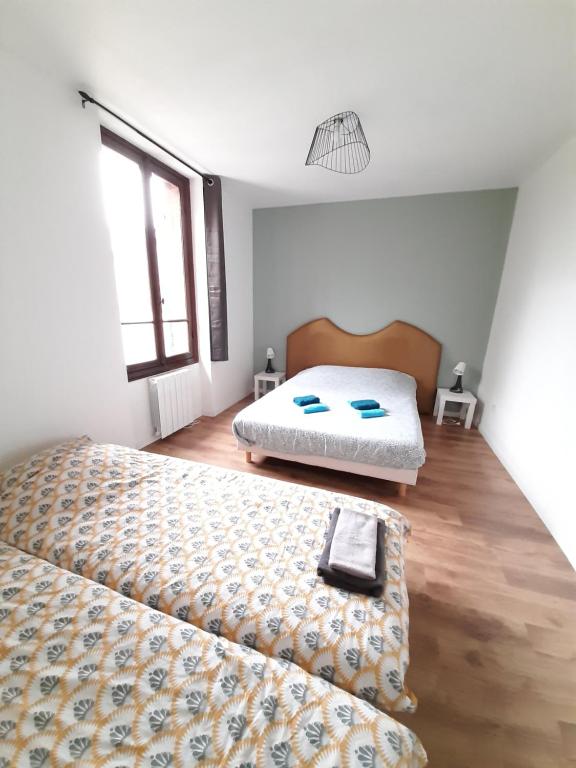 a bedroom with two beds and a wooden floor at Résidence du Houx - 4 (Astérix, Aéroport CDG, Chantilly, Parc expos...) in Survilliers