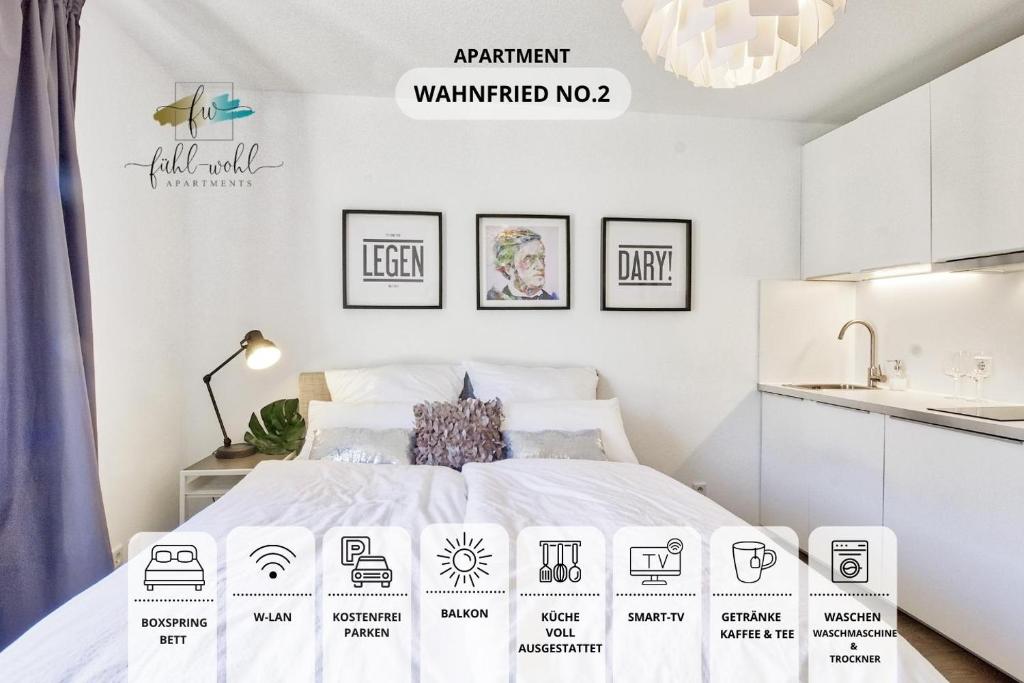 un dormitorio blanco con una cama con letreros en blanco y negro en Apt Wahnfried No2 - sehr zentrales, ruhiges Cityapartment mit Balkon, Küche, Duschbad & Parkplatz, en Bayreuth