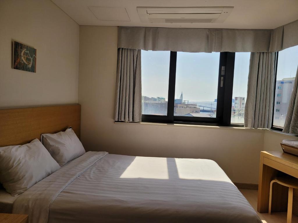 Postel nebo postele na pokoji v ubytování BK Hotel Jeju