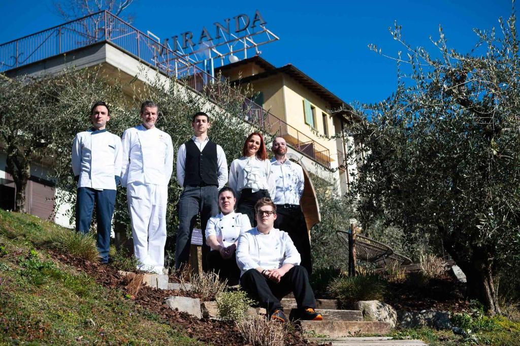 a group of people posing for a picture in front of a house at Hotel Miranda in Riva di Solto