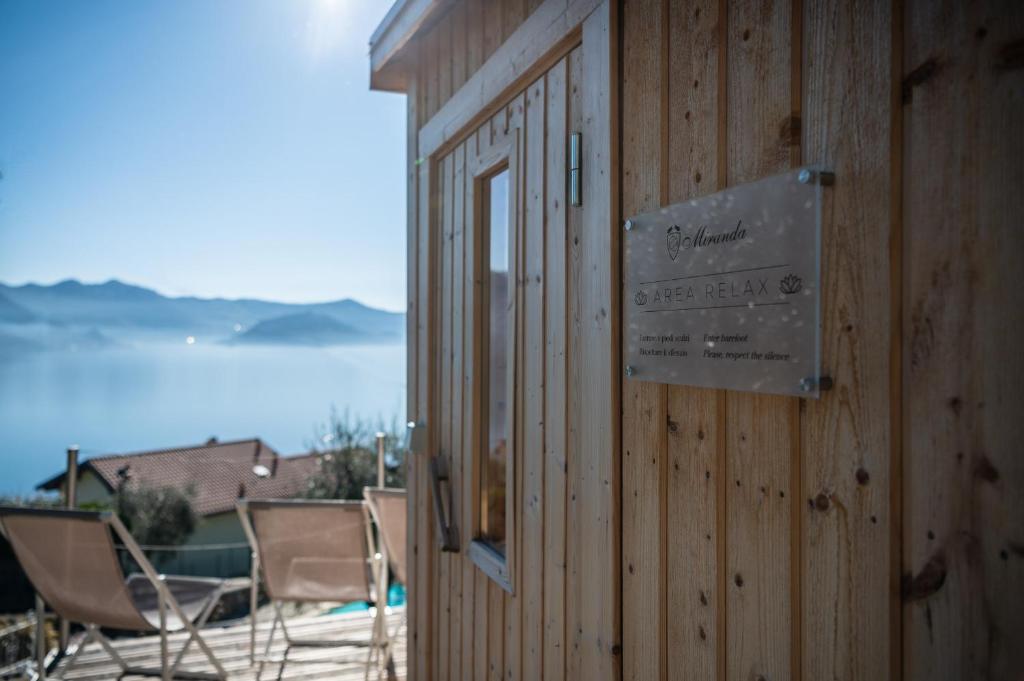 a sign on the side of a building with chairs at Hotel Miranda in Riva di Solto
