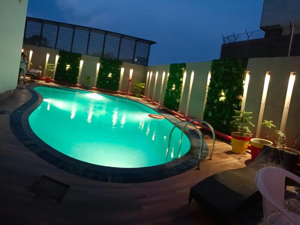 a large swimming pool in a building at night at Surasena Regal Vista Agra in Agra