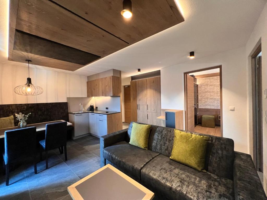 ein Wohnzimmer mit einem Sofa und einer Küche in der Unterkunft Adlhof Apartments in Bruneck
