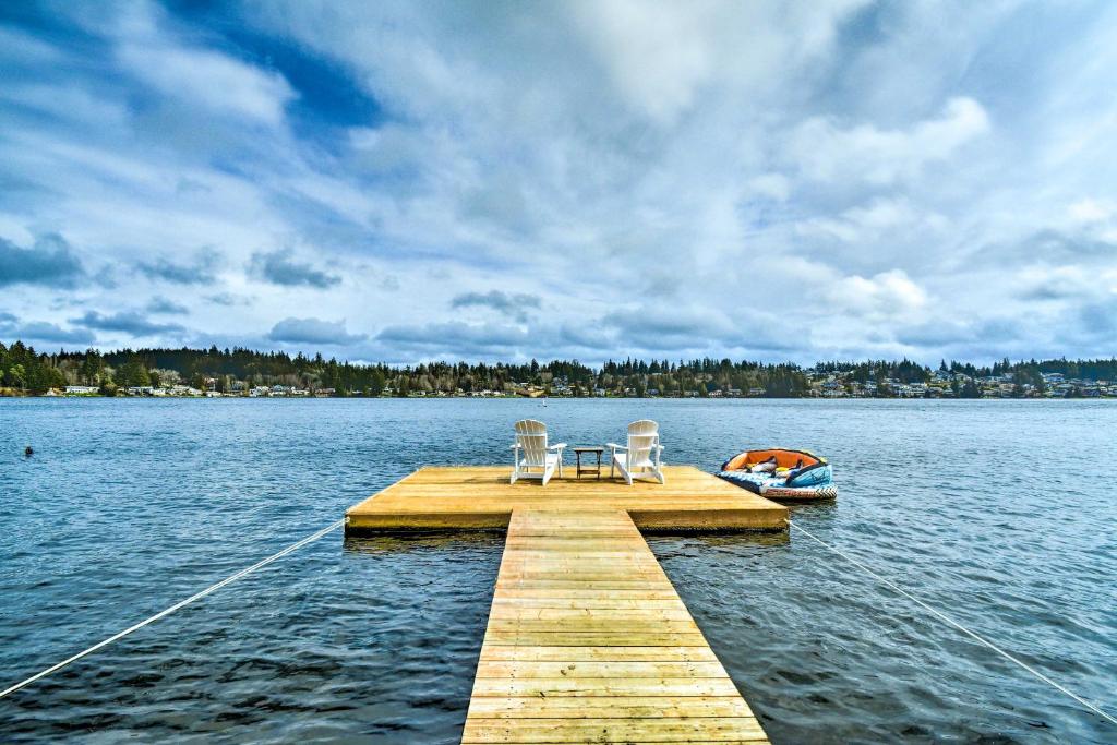 - un quai avec 2 chaises et un bateau sur un lac dans l'établissement Lakefront Bremerton Vacation Rental with Deck!, à Bremerton