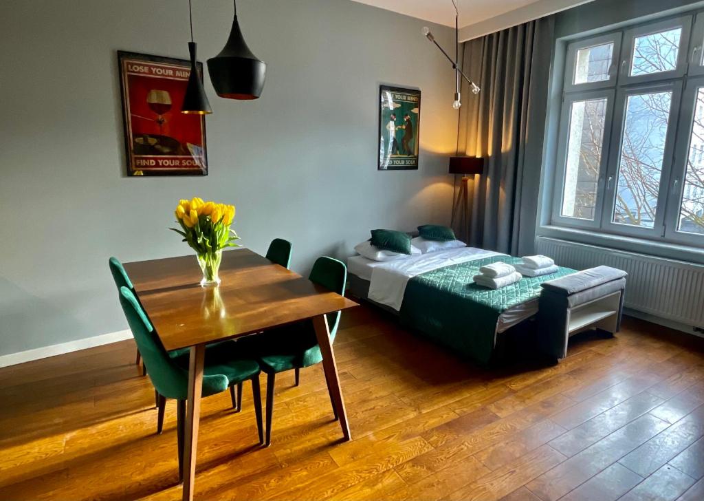 1 dormitorio con mesa, cama, mesa y sillas en Lou Lou Apart Wawel en Cracovia