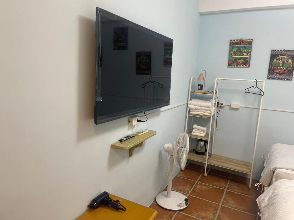 um quarto com uma televisão de ecrã plano na parede em See Hualien Homestay em Hualien