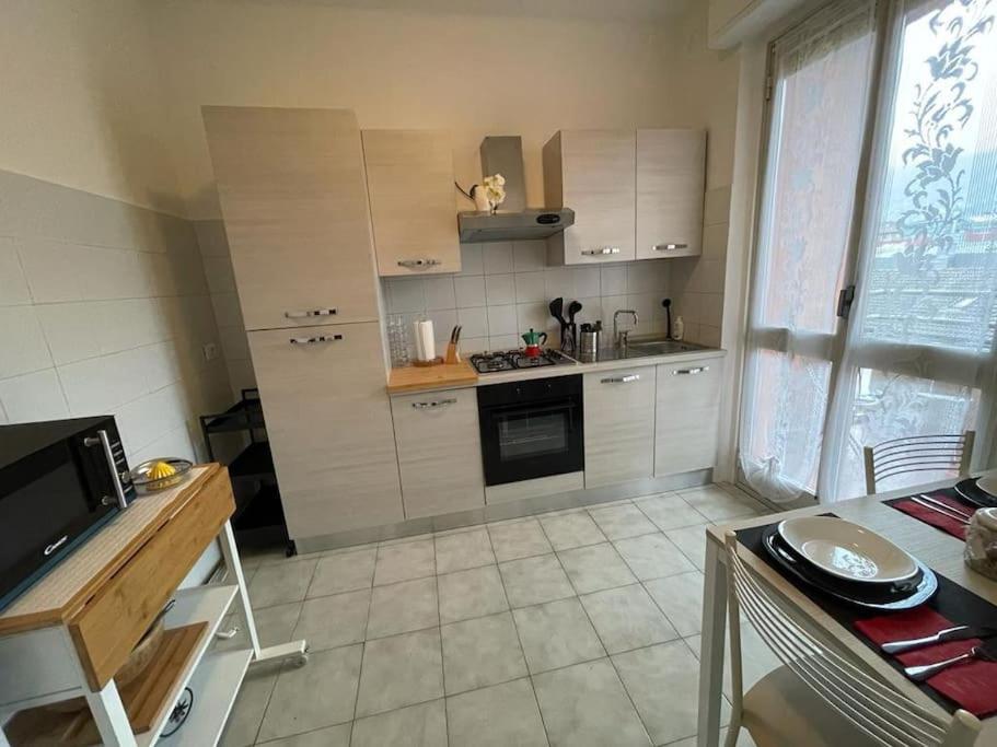 Una cocina con gabinetes blancos y un horno de estufa. en Como Lake House, vista lago: 100 mt dal lago, en Como