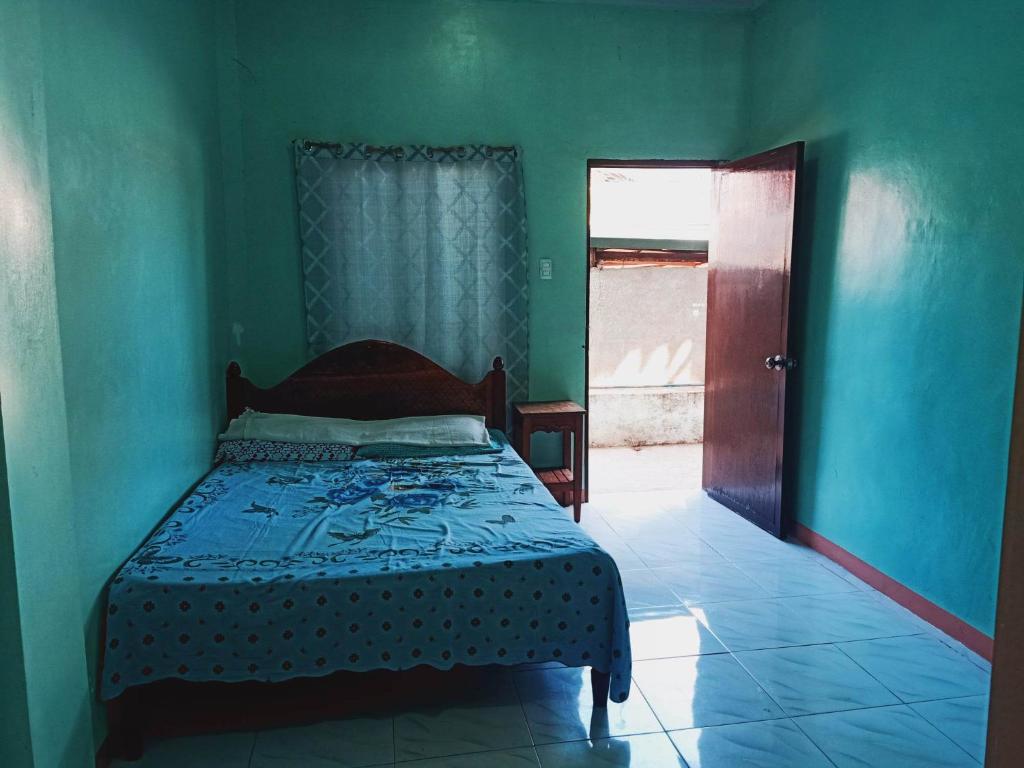 1 dormitorio con 1 cama en una habitación verde en NatureswayBudget room Travel, en Corón