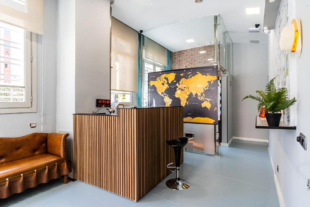 un vestíbulo con un sofá marrón y un mapa mundial en la pared en Hostel Center Madrid en Madrid