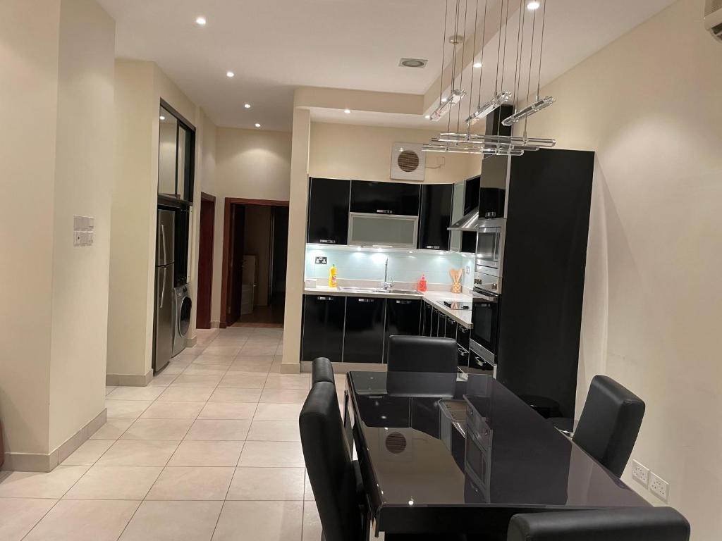 uma sala de jantar com uma mesa preta e cadeiras pretas em Premium 2 Bedroom Flat em Manama