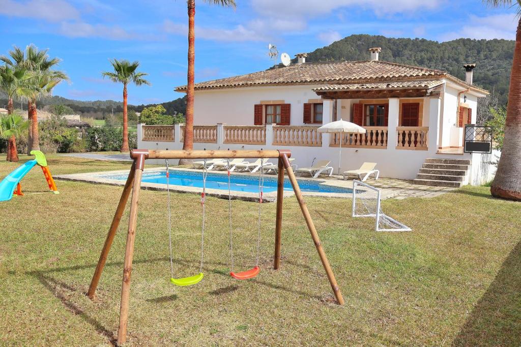 a backyard with a swing set and a pool at Villa Can Mussol 040 by Mallorca Charme in Sa Pobla