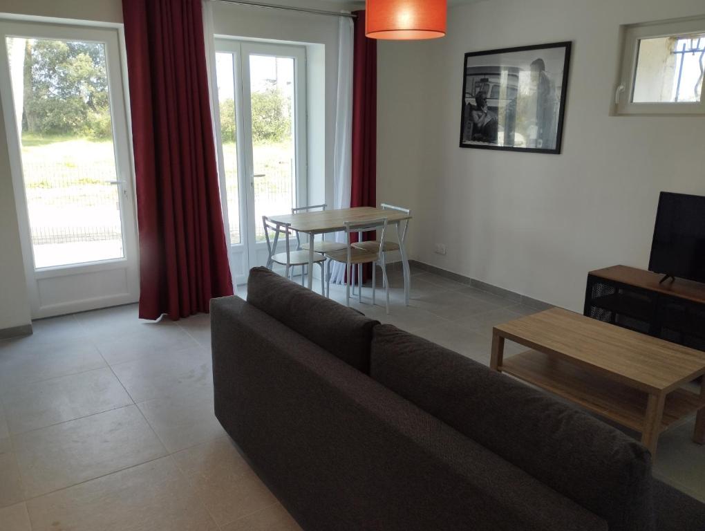 sala de estar con sofá y mesa en Appartement meublé et tout confort, au milieu de la campagne, en Saint-Paul-Trois-Châteaux