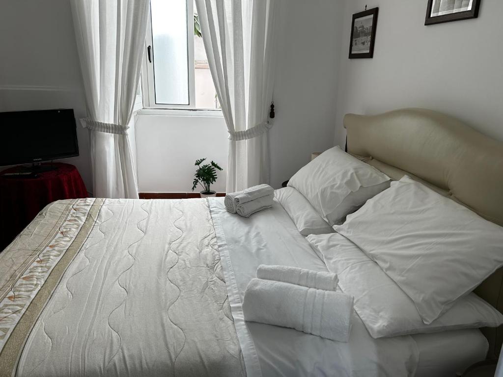- un lit blanc dans une chambre avec fenêtre dans l'établissement Home Marty, à Naples