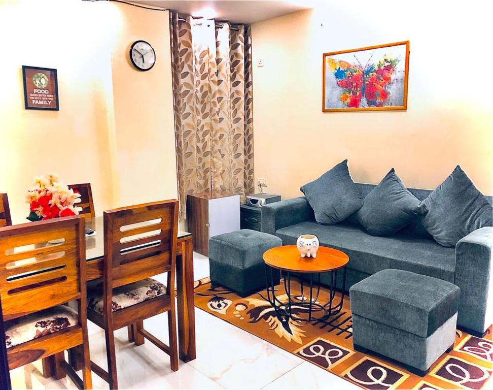 a living room with a blue couch and a table at 2BHK Independent Service Apart with Lift in Vasant Kunj New Delhi in New Delhi