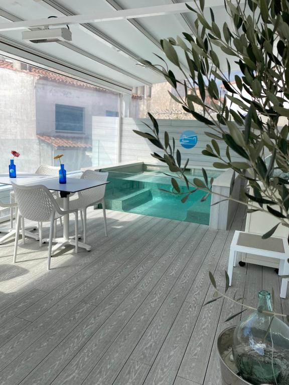 a room with a table and chairs and a swimming pool at Mamma Mia Hotel Boutique - Only Adults in Tossa de Mar