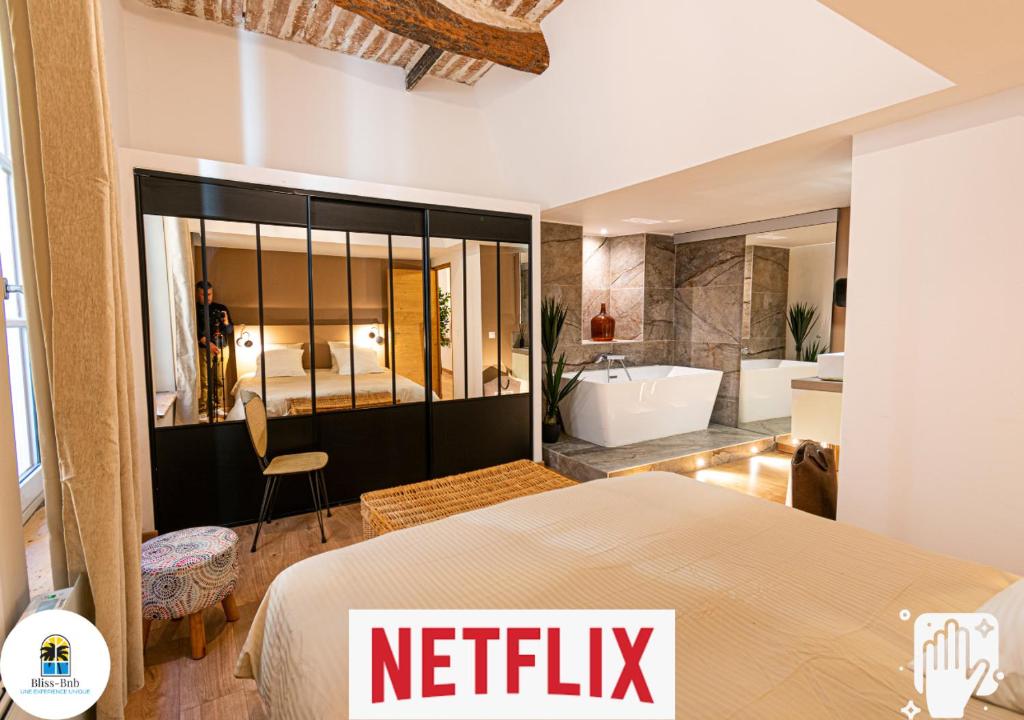 een slaapkamer met een bed en een badkamer met een bad bij Loft au bèu mitan - 50m2 in Grasse