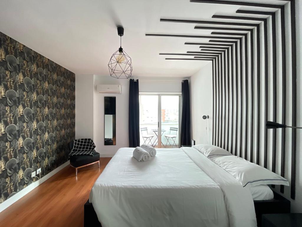 1 dormitorio con cama blanca y ventana grande en Apartments City Center • Collection by Perpetual Relax en Braga