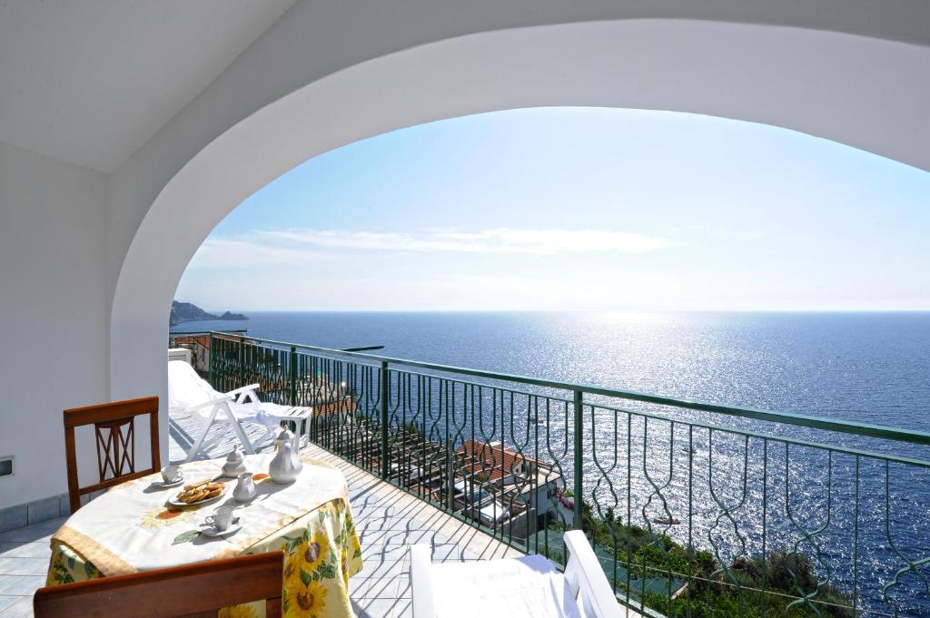 a balcony with a table and a view of the ocean at Alba di Praiano in Praiano
