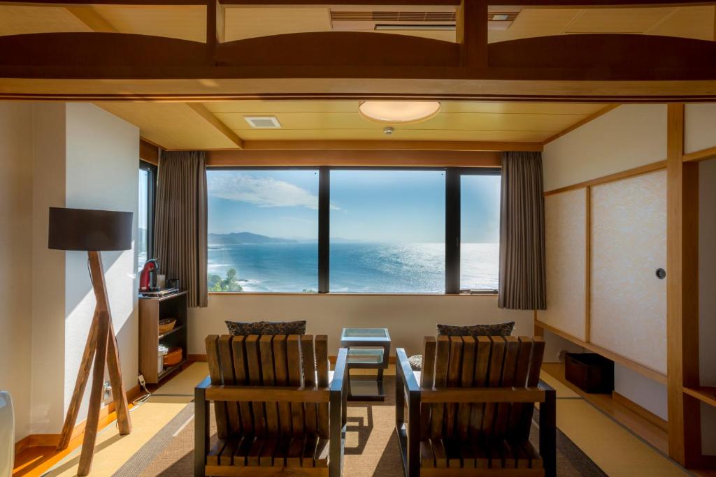 a living room with a table and chairs and a large window at Jukaitei in Kyotango