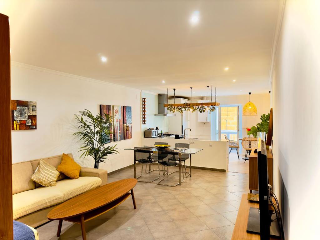 un soggiorno e una cucina con un divano e un tavolo di La Primera de Occidente a Cadice